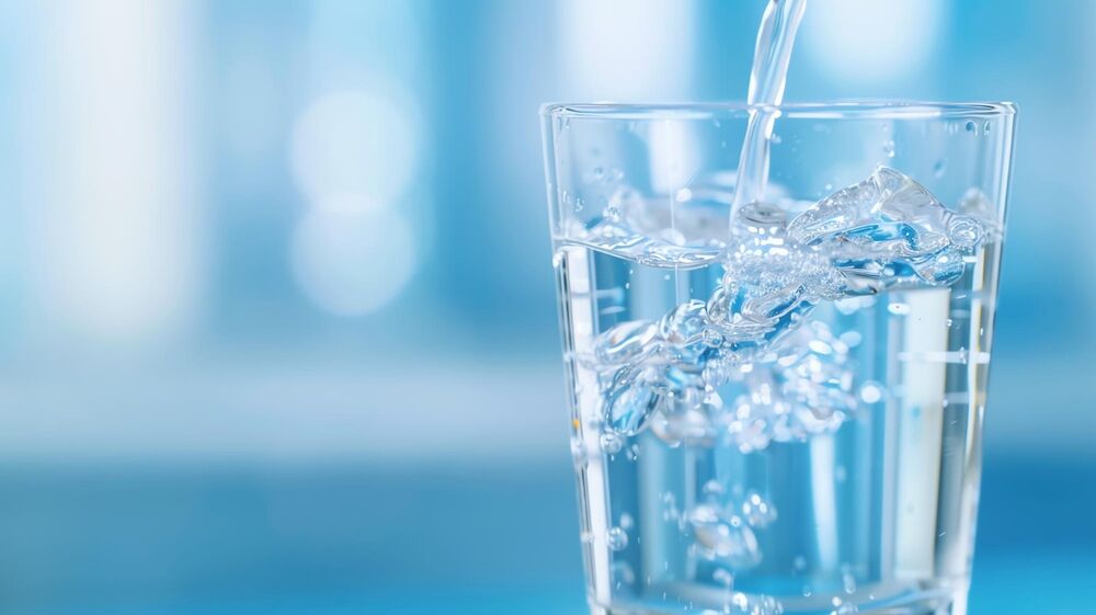 Glas wird mit Wasser befüllt