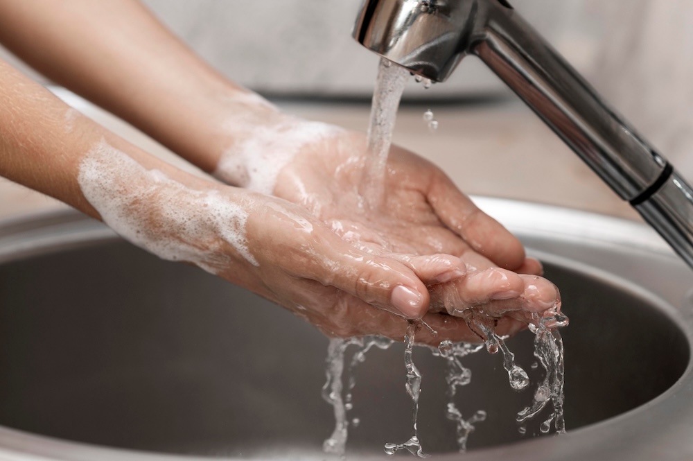 Eine Person wäscht Ihre Hände unter dem Wasserhahn